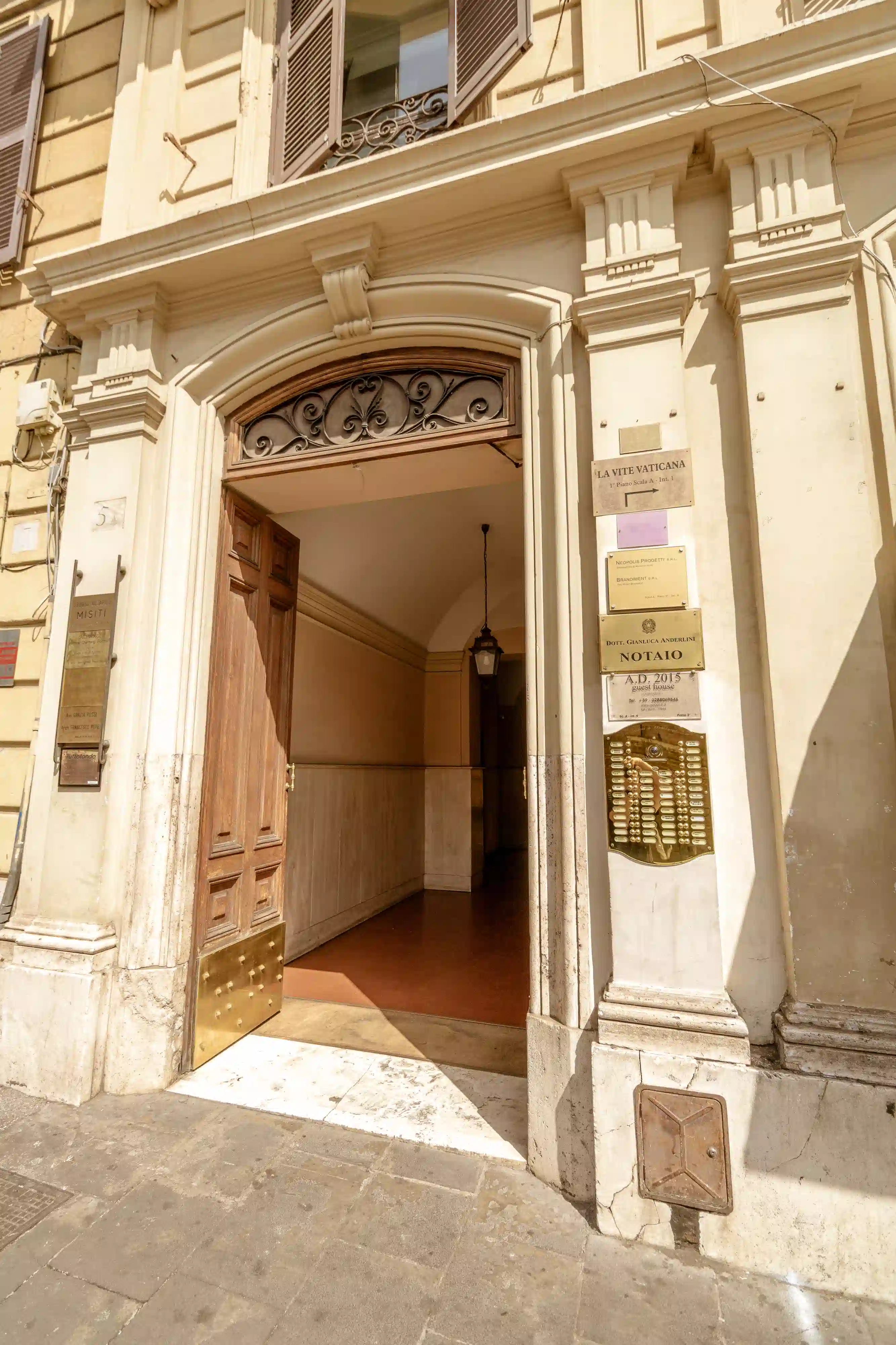 Close-up of the imposing entrance door with decorative iron scrollwork and brass plaques