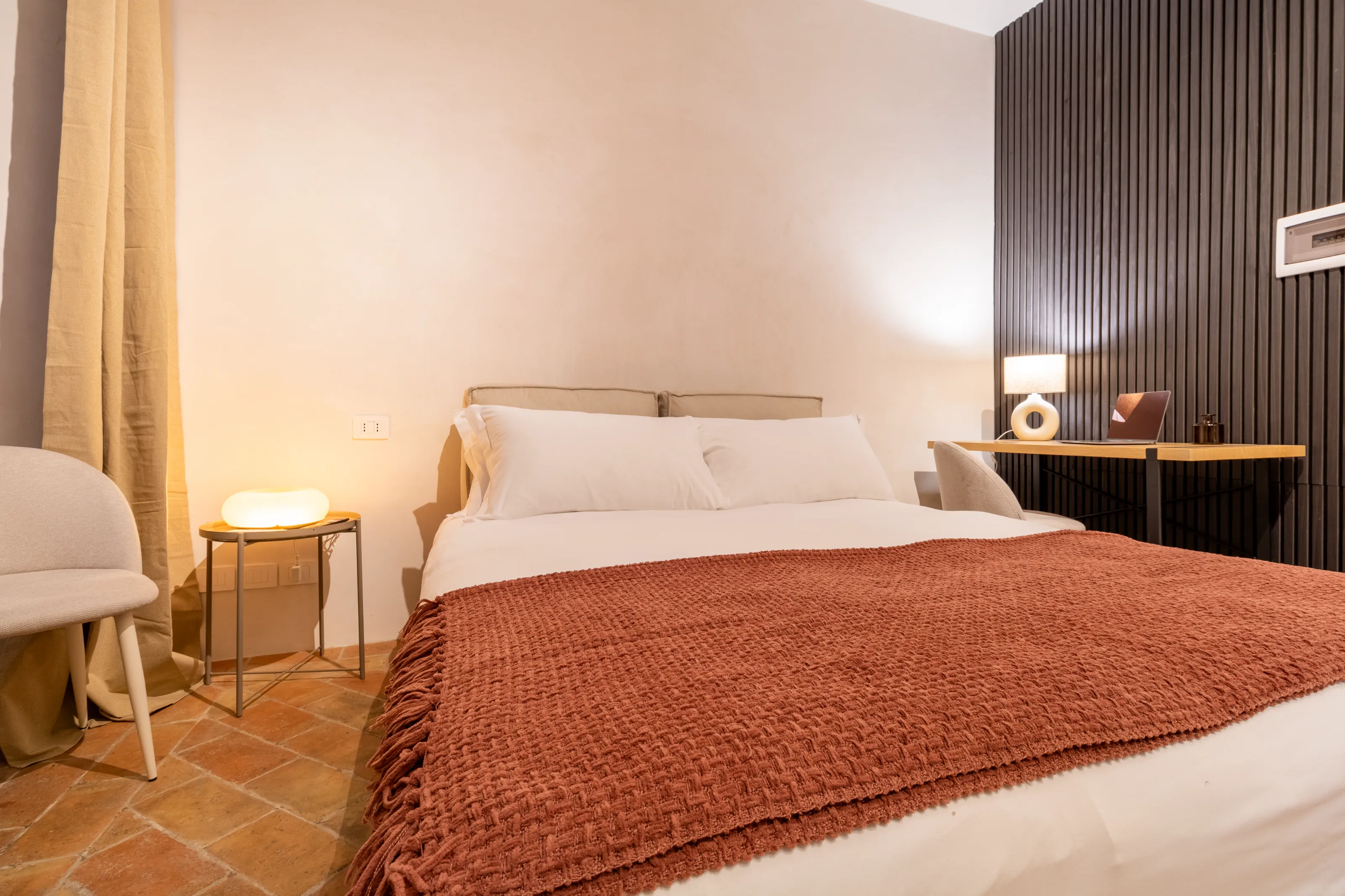 Cozy double room with warm lighting and work desk