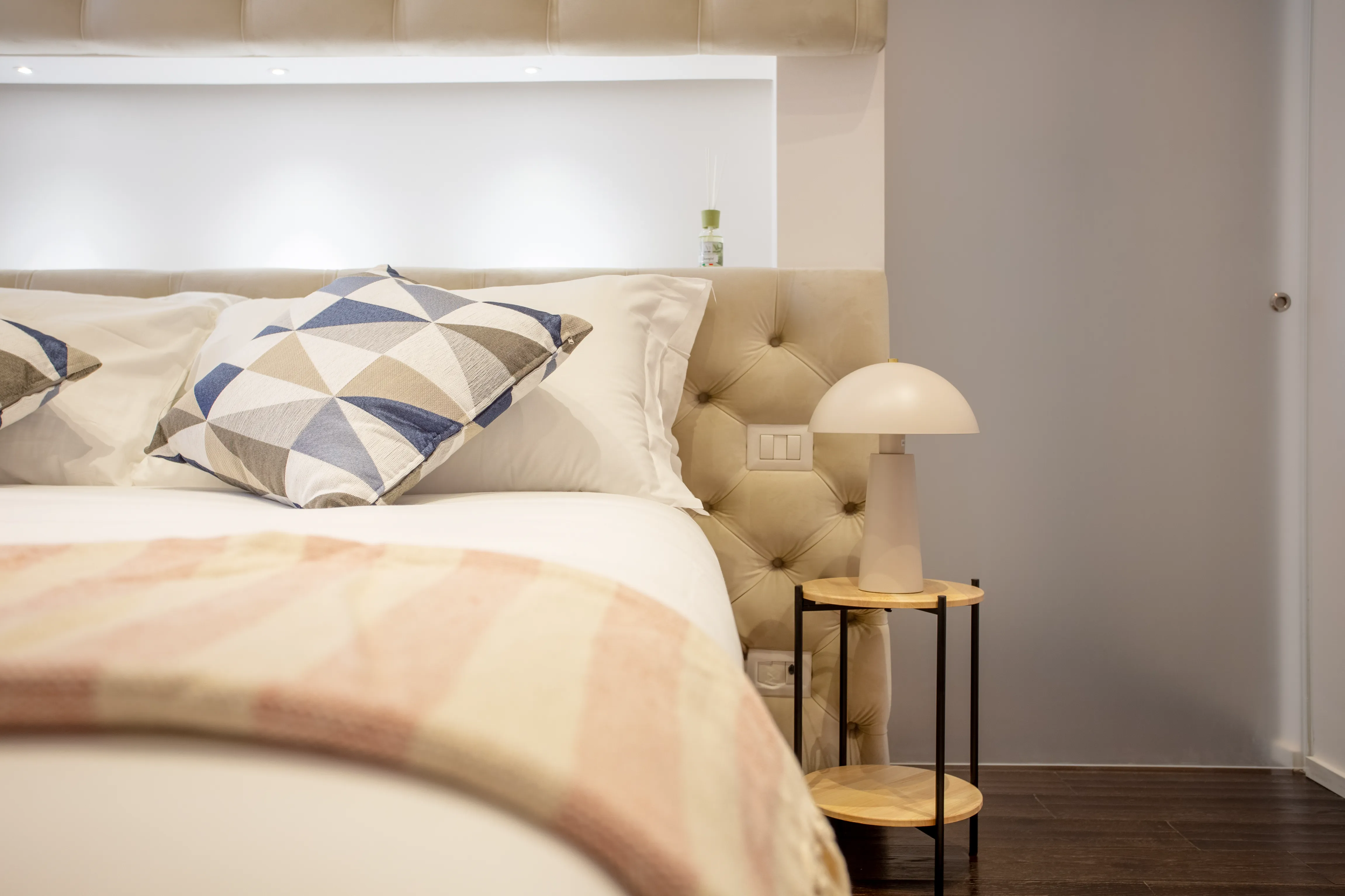 Comfortable bed with soft pillows and bedside lamp
