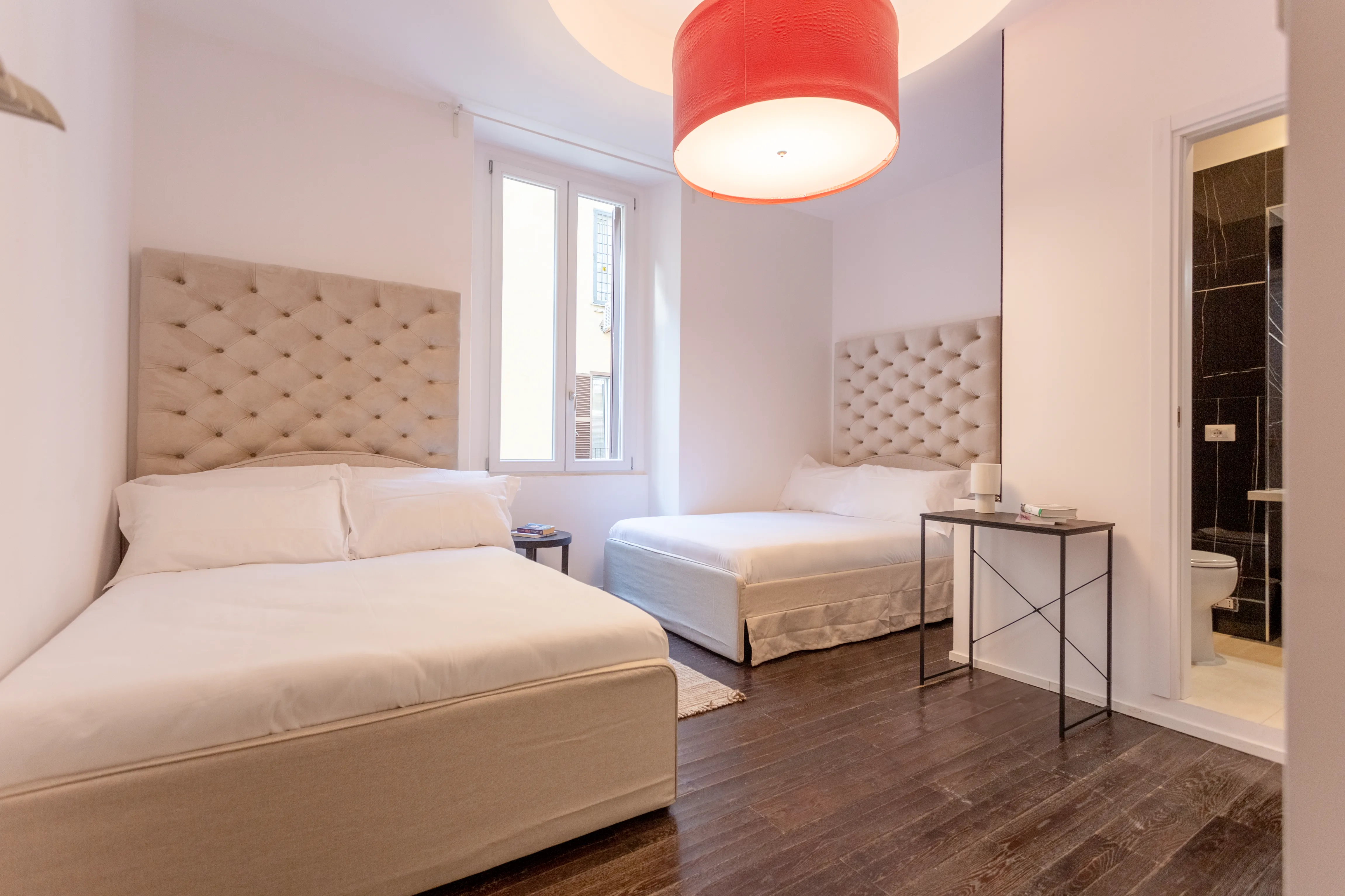 Beds with elegant headboards and natural light from large windows