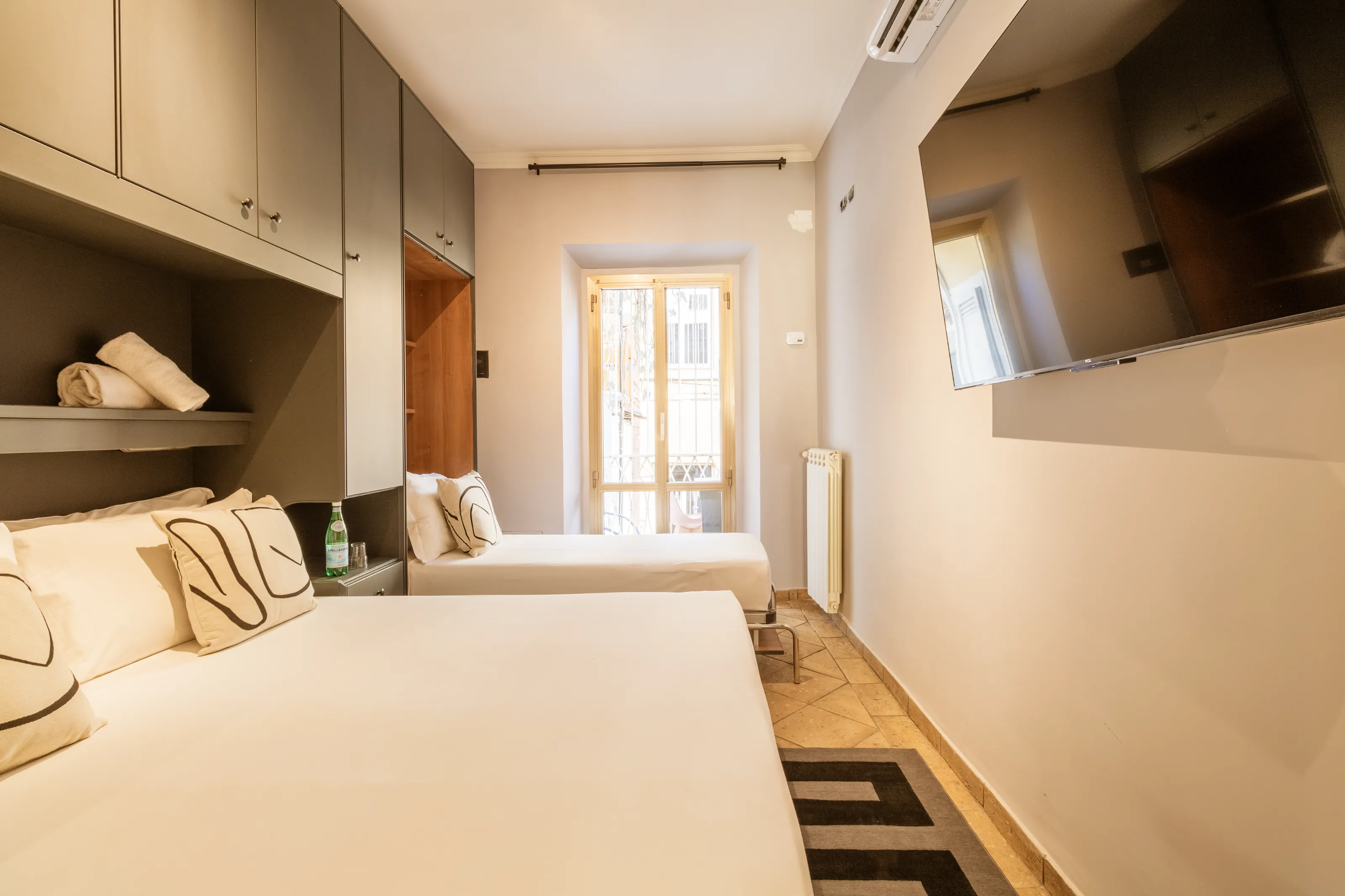 Modern guestroom with two comfortable beds and a large flat-screen TV